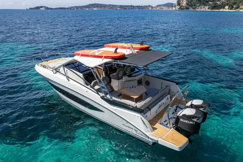 Boat with paddleboards from above in clear Mediterranean water
