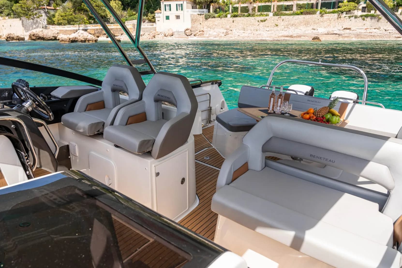 Beneteau cockpit with rosé bottles and fruit bowl on deck